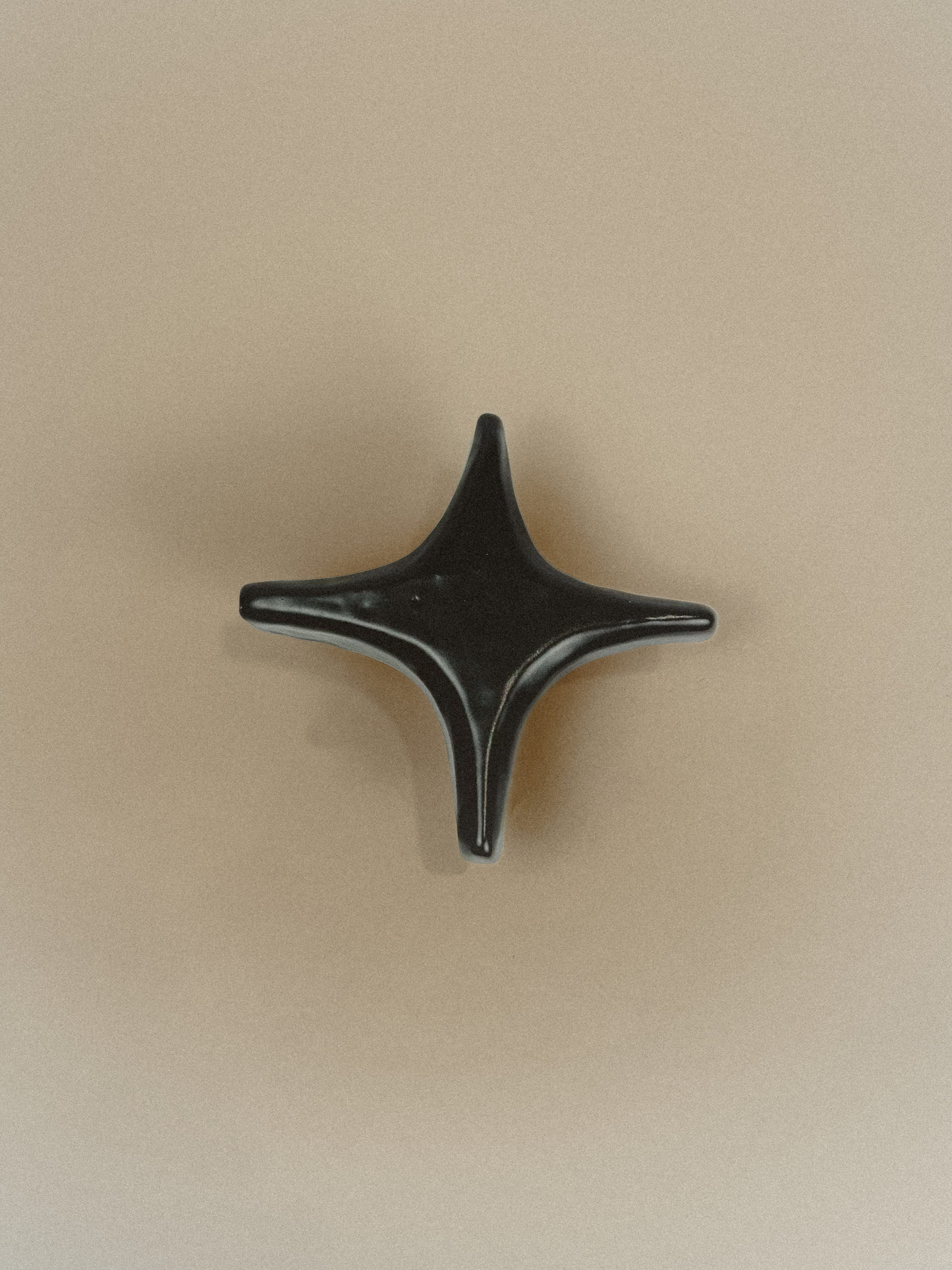 Black star-shaped object on a beige background